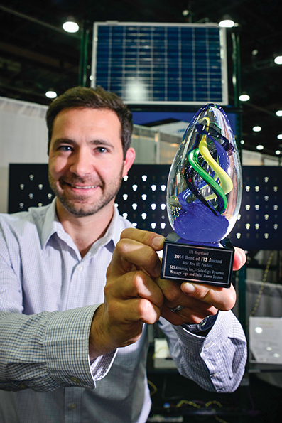 Brandon Tessier of SES America displays the award SES America SolarSign